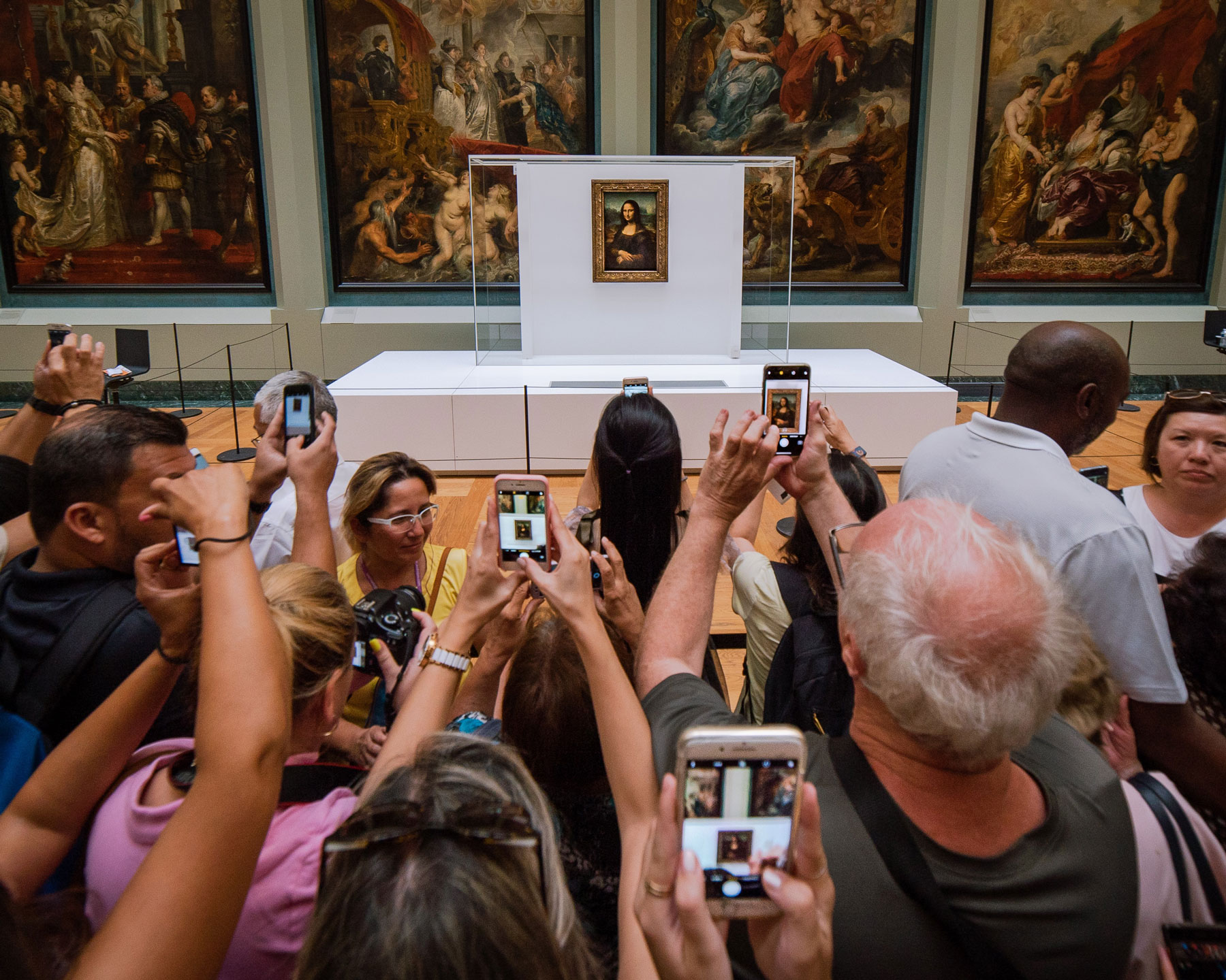 crowd taking photos of mona lisa painting