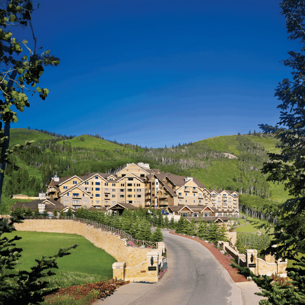 Luxury resort nestled in the mountains with a winding road and scenic landscape.
