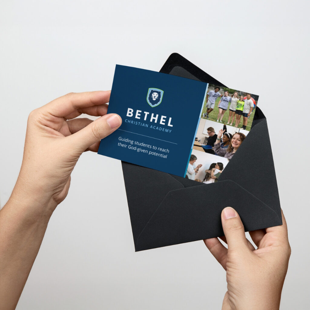 Bethel Christian Academy - person holding dark blue brochure with modern logo and printed inserts.