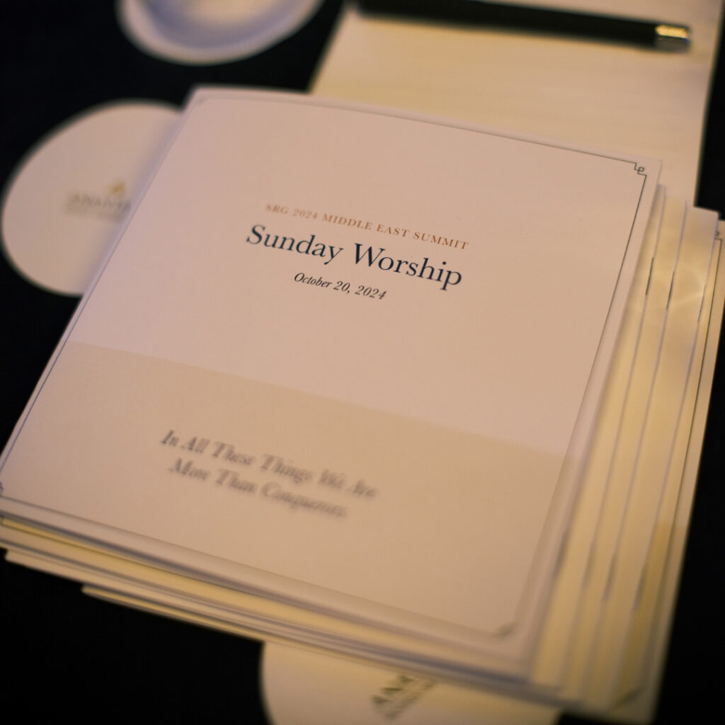 Close-up of printed worship service programs stacked on a table.