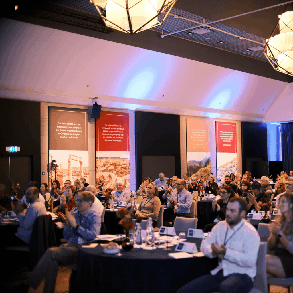 Audience attending a corporate event or conference in a large banquet hall.