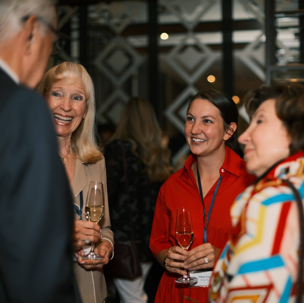 Attendees networking and chatting at a formal event reception.